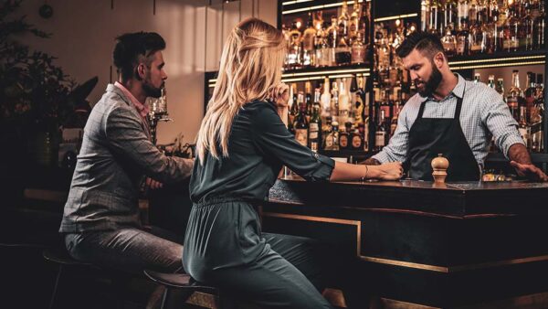 Couple sat at bar ordering drinks