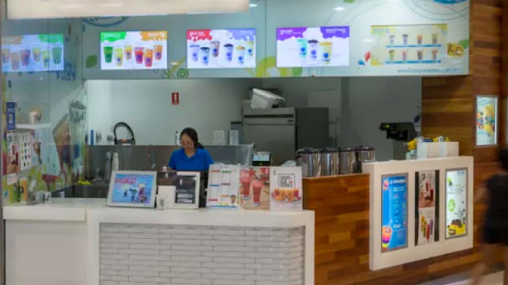 Staff member uses till behind counter at EasyWay Tea