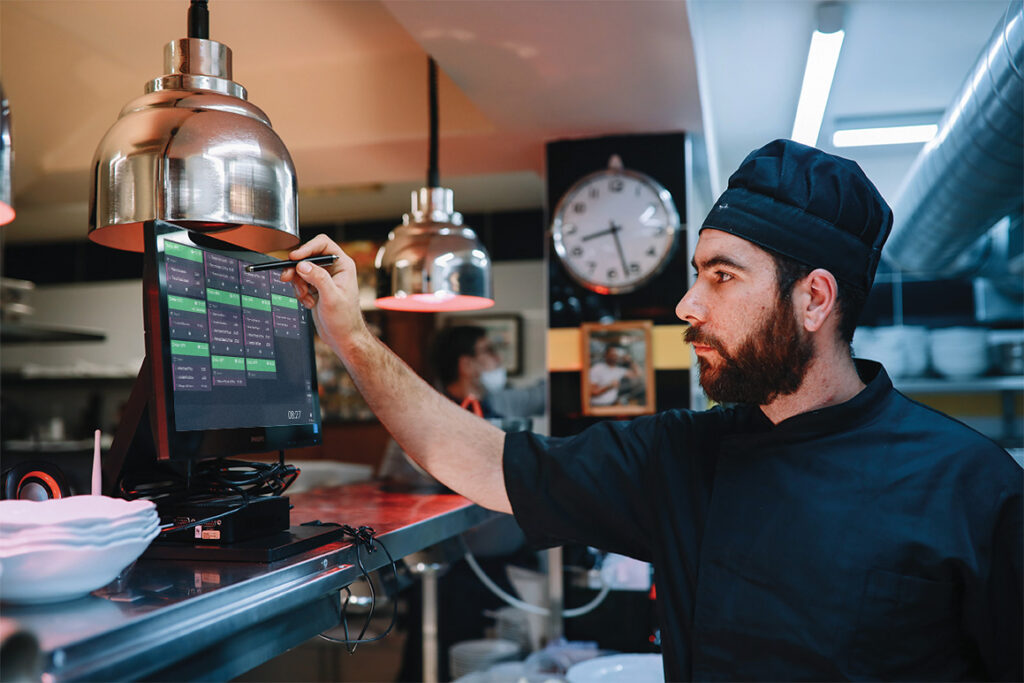 A chef utilising an ICRTouch TouchKitchen digital kitchen display system