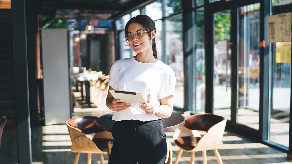 Waitress smiling at camera holding tablet