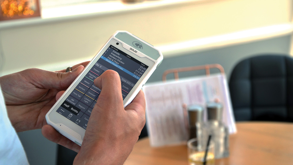 Employee taking a table's order on a tablet
