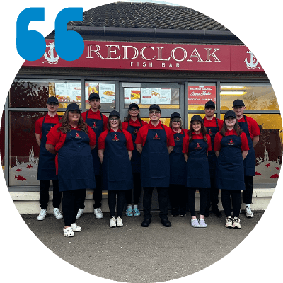 Photo of staff in front of Redcloack Fish Bar with a quote